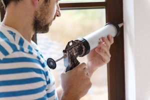 fall home improvement projects include sealing gaps around windows with caulk
